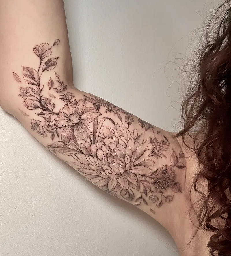 Tatuaggio floreale fine line sul braccio con dalia e piccoli fiori, copertura di cicatrici