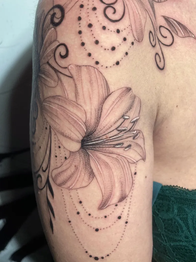 Tatuaggio di un giglio con volute e motivi a puntini sul braccio