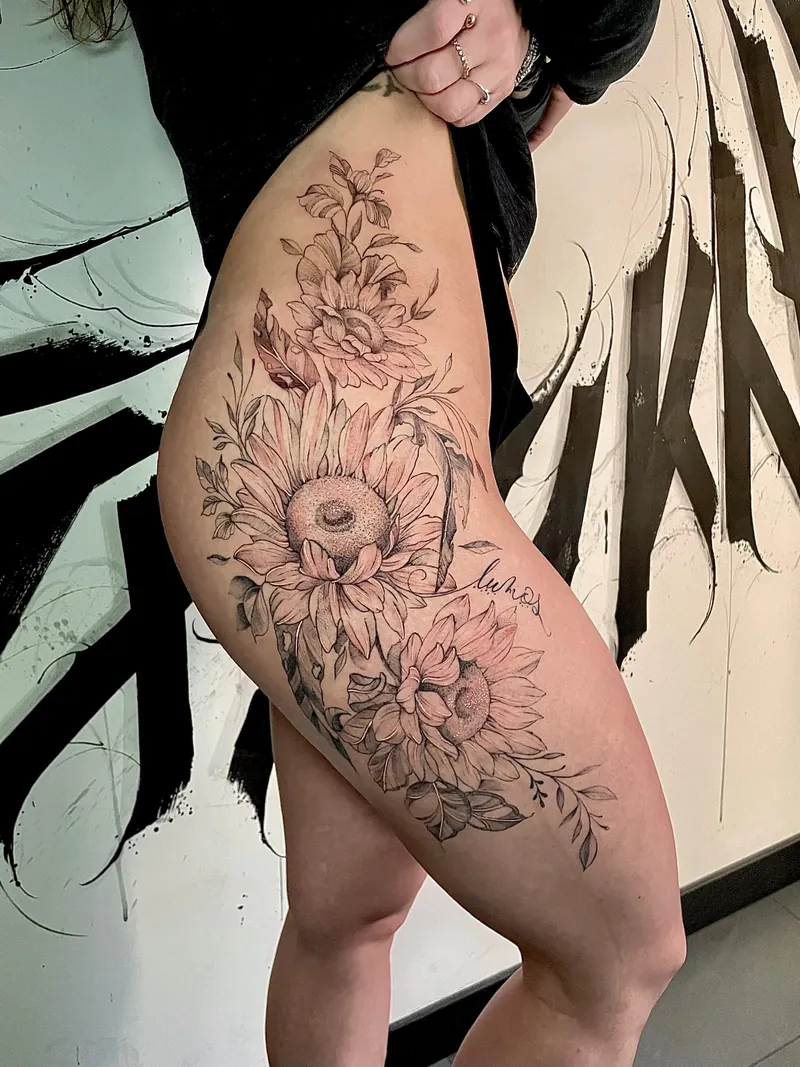 Tatuaggio floreale fine line con girasoli e foglie su fianco e coscia