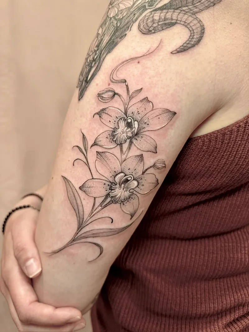 Tatuaggio fine line di due orchidee sul braccio