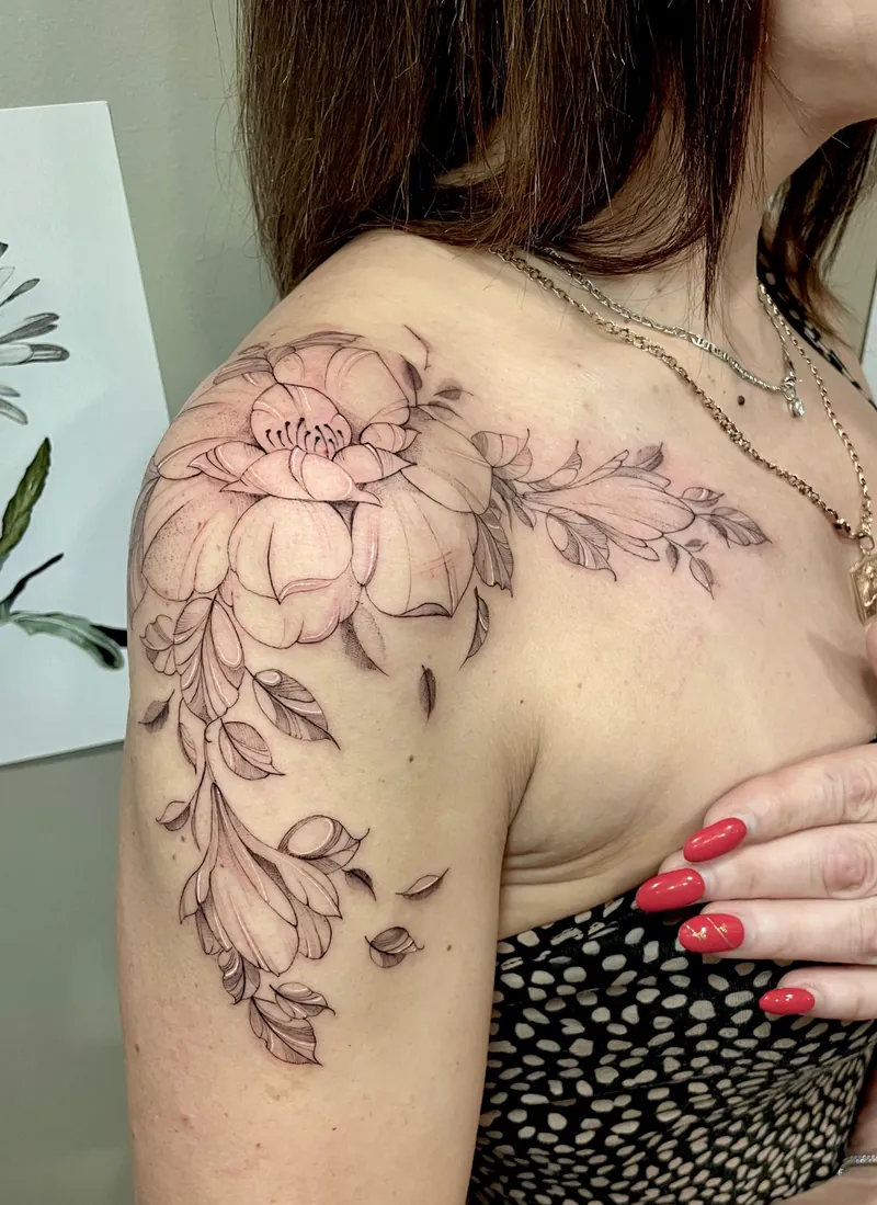 Tatuaggio floreale fine line con una peonia e rametti fioriti dalla spalla al braccio