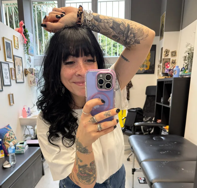 Valentina, tatuatrice di ValeMomi Tattoo, nel suo studio mentre si fotografa allo specchio